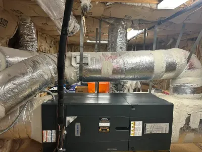 Industrial cooling system insulation and ductwork installation in a commercial building.