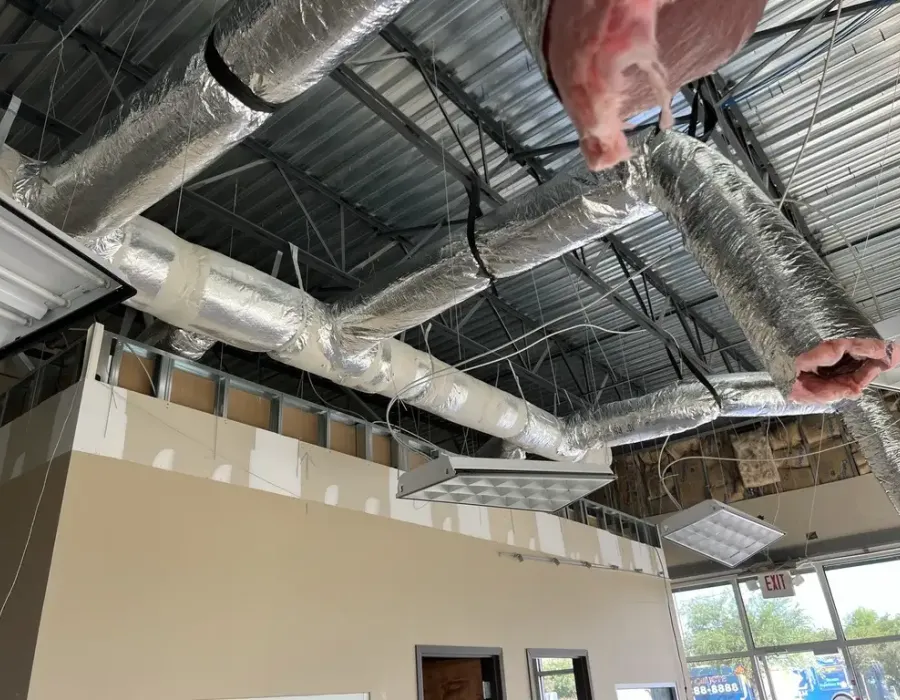 Industrial cooling system insulation and ductwork installation in a commercial building.