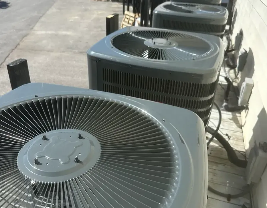 Row of American Standard commercial HVAC units installed outdoors alongside a building wall.
