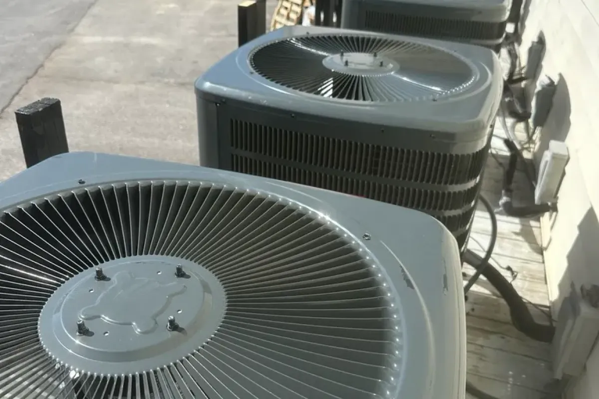 Row of American Standard commercial HVAC units installed outdoors alongside a building wall.