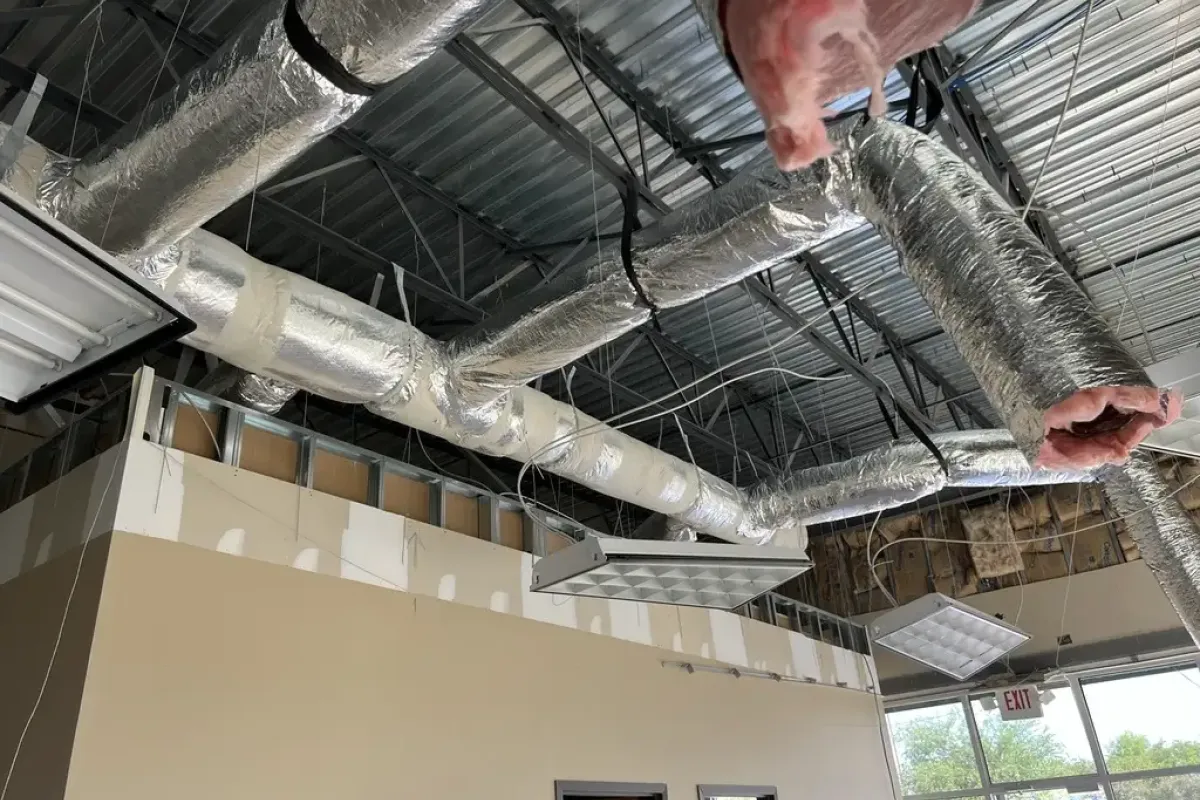 Industrial cooling system insulation and ductwork installation in a commercial building.